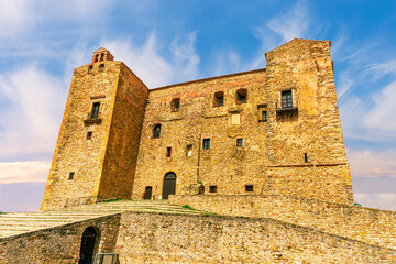Fototapeta premium wonderful view at ancient medieval old castle or fortress in traditional Norman style with antuqoe walls and towers with beautiful blue cloudy sky on background of landscape