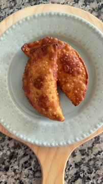 SLOW MOTION SHOT - Fried Pastry on a plate. Brazilian street food pastel, Top View.