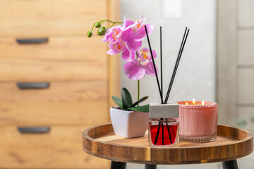 Aromatic reed air freshener on wooden table.Diffuser with natural fruity, floral, spicy aroma.interior scent. Luxury perfume for the home.Orange, lime, coffee, cinnamon, star anise, vanilla and orchid