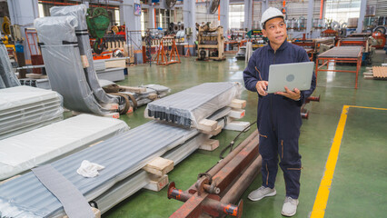 Professional Senior Asian technician engineer or inspector is using laptop in manufacturing factory planning production schedule, or doing a quality control checklist. Concept of technology in factory