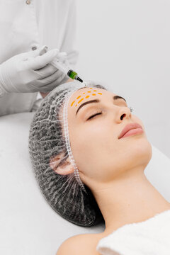 Close-up of a cosmetologist performing a facial peel on a young woman. Concept of professional care, rejuvenation, and healthy skin.