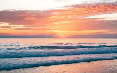 Obraz premium Golden Hour Coastal Serenity: A vibrant sunset paints the sky in hues of orange and pink, casting a warm glow on the gentle waves crashing on the sandy shore.
