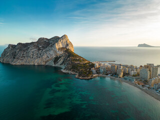 Aerial drone view of Calpe city. View of Ifach Mountain. Beautiful sunset colours reflecting on...