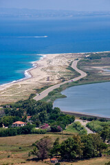 Coastal road winds along a scenic beach, lagoon, and turquoise sea.  A tranquil summer landscape.