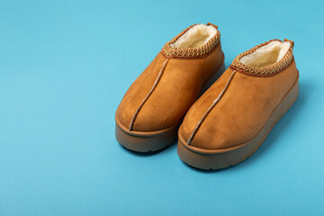 Soft slippers on a bright colored background, close-up. House slippers. Comfortable shoes for home. Foot care concept. Home comfort. Space for text. Copy space.