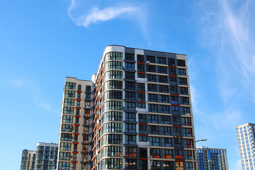 A very tall building stands prominently beneath a clear blue sky