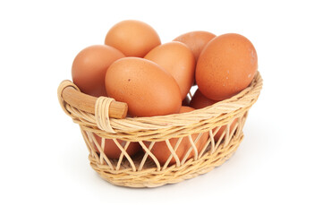 Brown eggs in wicker basket close up on a white background