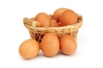 Brown eggs in wicker basket close up on a white background