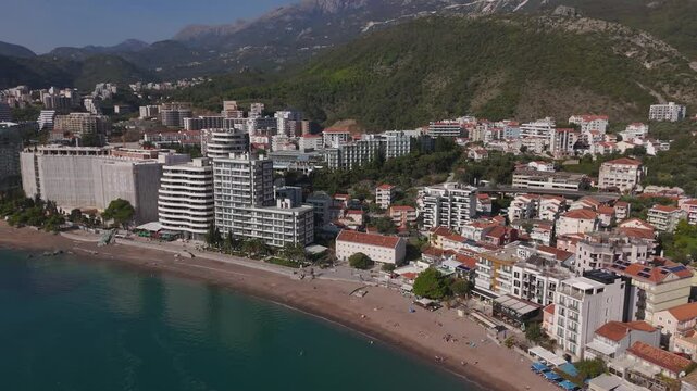 Aerial drone view of Rafailovici town coastline and turquoise sea bay in Budva riviera, Montenegro. Beautiful Mediterranean summer travel destination.
