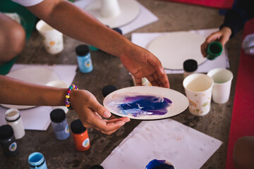 Fluid art. Master class for children on drawing. Art therapy. Drawing with acrylic paint on a round canvas. A group of children develops creatively.