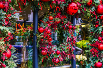 Christmas wreath with red balls and a wooden chair just below it