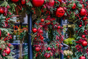 Christmas wreath with red balls and a wooden chair just below it
