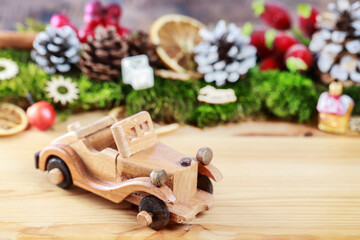 Wooden toy car among classic Christmas decorations.