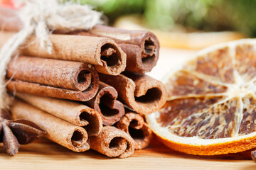 Cinnamon sticks and dried oranges on wooden table.
