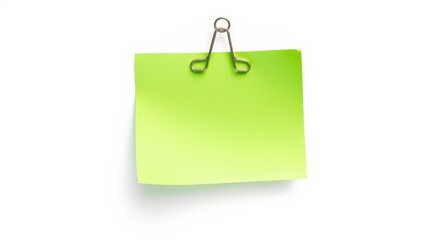 A bright green sticky note held by a metal binder clip on a stark white background