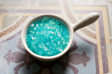 Bowl of blue sea salt in the bathroom.
