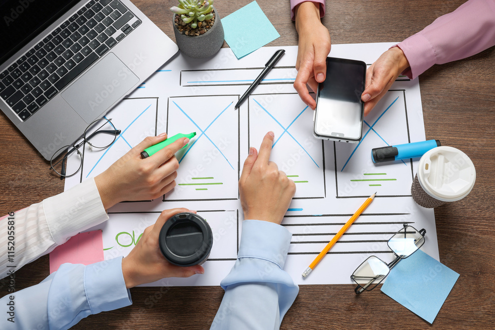 Aufkleber developing ui design. designers creating website wireframe on paper at wooden table, top view