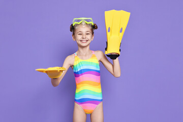 Happy girl in beachwear with diving mask and flippers on purple background © New Africa