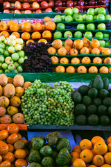 Beautiful display of fresh fruits including oranges grapes avocados apples and cherimoya in a Peruvian marketplace