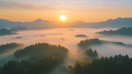 A serene sunrise over misty mountains and forests, creating a tranquil landscape.