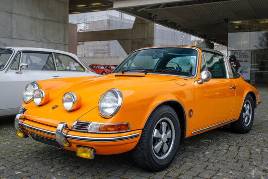Classic orange Porsche 911 T Targa top in urban setting 
