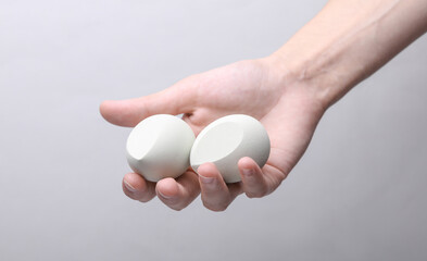 Female hand holding makeup sponges on gray background