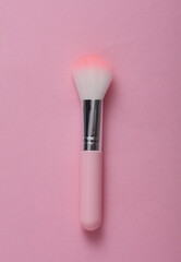 Makeup brush on pink background. Minimalism