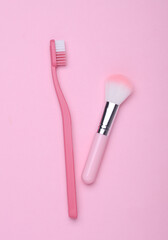 Makeup brush and toothbrush on pink background