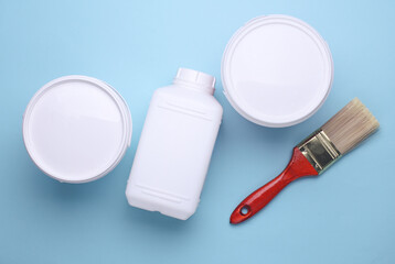 Clean paintbrush with paint cans on blue background. Top view