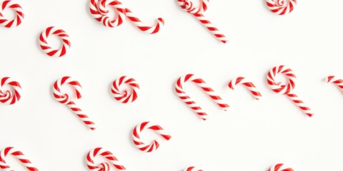 A festive arrangement of traditional candy canes on a stark white background, showcasing the classic red and white stripes in a variety of orientations, creating a playful and celebratory visual