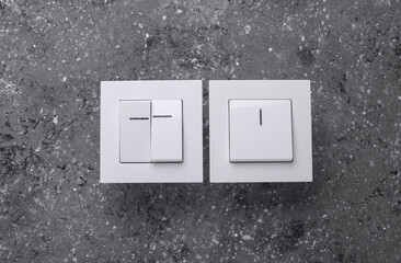 Two Light Switches on a Grey Concrete Background
