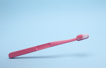 Plastic toothbrush floating on blue background. Dental care