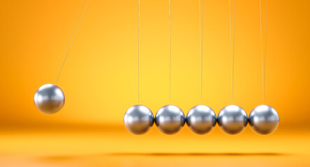 Newton's cradle showing cause and effect on orange background