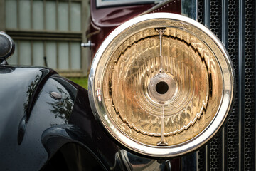 Close-up of details of headlight, fender and grille of classic pre-war