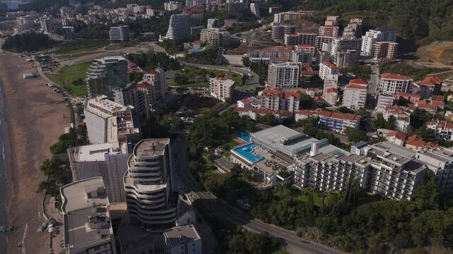 Aerial view of Rafailovici town coastal houses, streets and roads. Beautiful resort town landscape in Montenegro from above.

