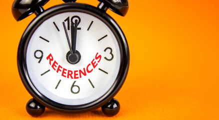 References or reference symbol. Concept word References on beautiful orange paper. Beautiful orange paper background. Black alarm clock. Business references or reference concept. Copy space.