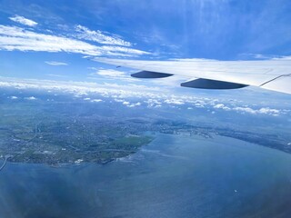 Above Chiba, Japan - Breathtaking Views of Blue Skies, White Clouds, and Diminishing Land from the Plane Window