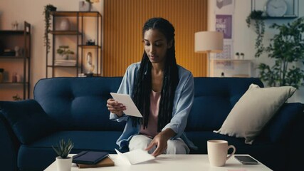 African American woman reads a good news letter about her university acceptance