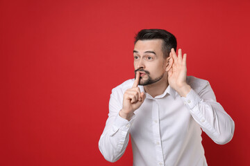 Man showing hand to ear gesture on red background, space for text