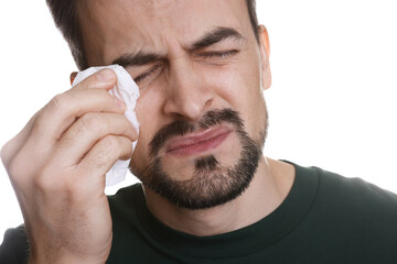 Sad man with paper tissue crying on white background