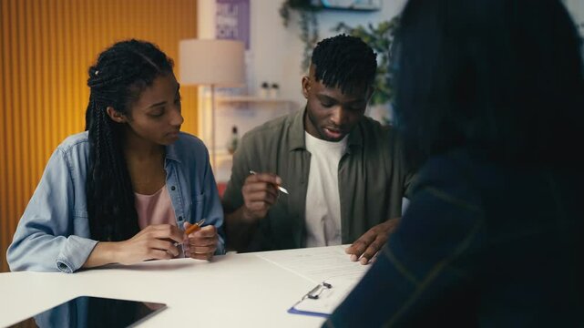 Black couple signs divorce papers in a notary office, facing relationship crisis