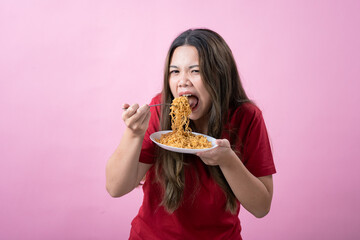 Young woman in a red shirt with long brown hair holds a fork and plate of noodles, shouting excitedly. The scene has a pink background, creating a lively and humorous atmosphere.