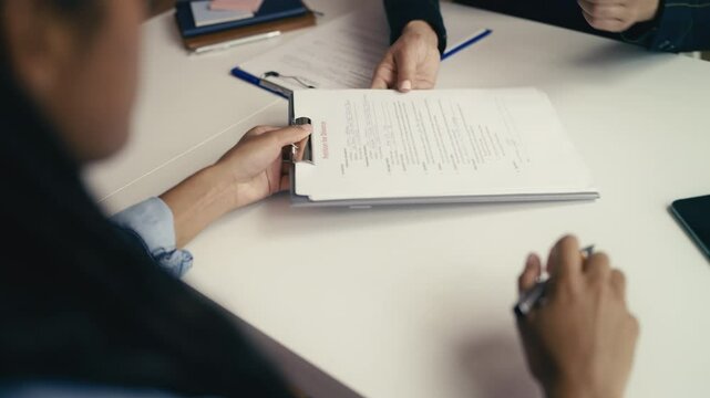 African American woman signs a divorce petition and shakes hands with her lawyer