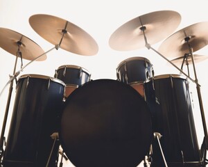 Silhouette of a classic drum set against a bright background, evoking a sense of rhythm and energy.