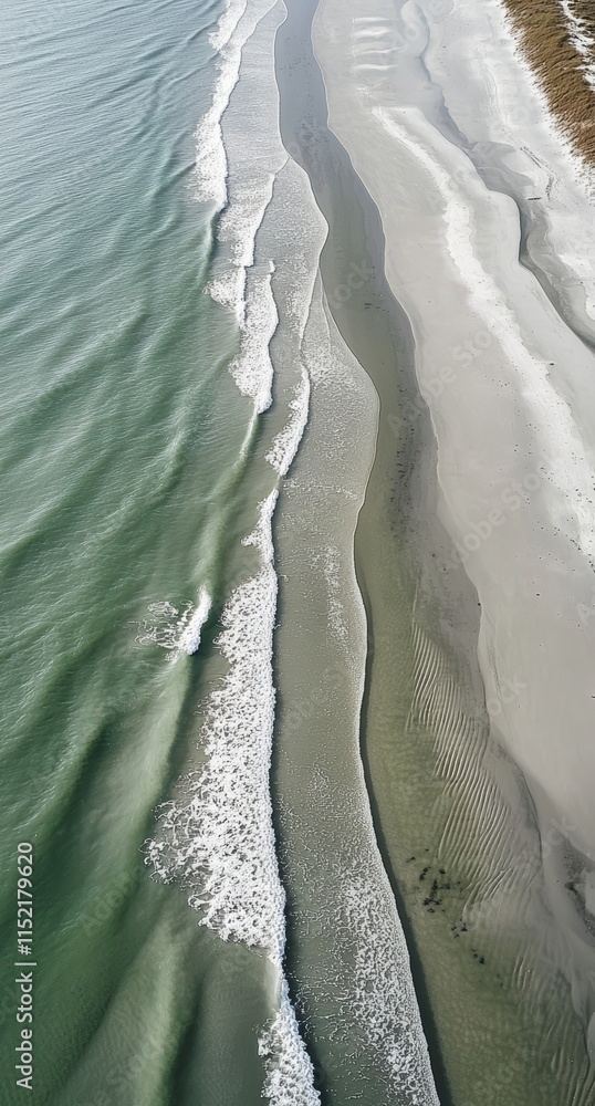 Poster gentle waves are rhythmically crashing on a pristine sandy beach, creating a mesmerizing display of 