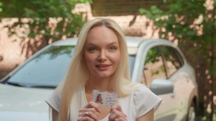 Happy satisfied Caucasian woman female girl car auto driver school student looking camera showing driving license drive automobile vehicle courses education successfully pass exam test at city street