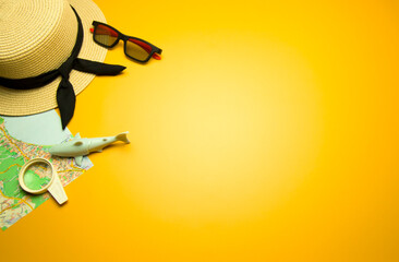 Straw hat, map, shark, sunglasses and magnifying glass on yellow sunny background. Summer holiday,...