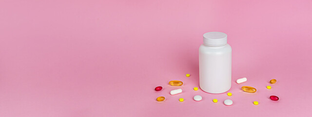 A banner with a jar of medicines and vitamins, pills and colorful capsules nearby. A concept for pharmacies, clinics, hospitals, pharmaceuticals, disease treatment, cold season. Copy space for text