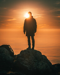 silhouette of a hiker on the top of a mountain at sunset