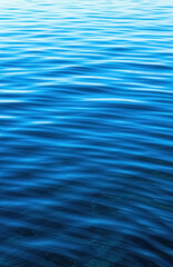 Naklejka premium Calm blue ocean waves ripple across the surface in sunlight